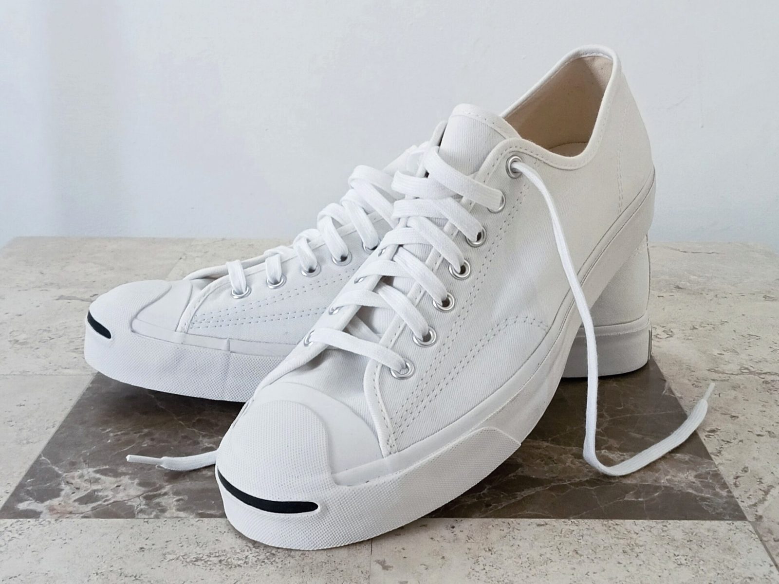 After relighting: the same white canvas sneakers, dim room, now bright and buyer-ready