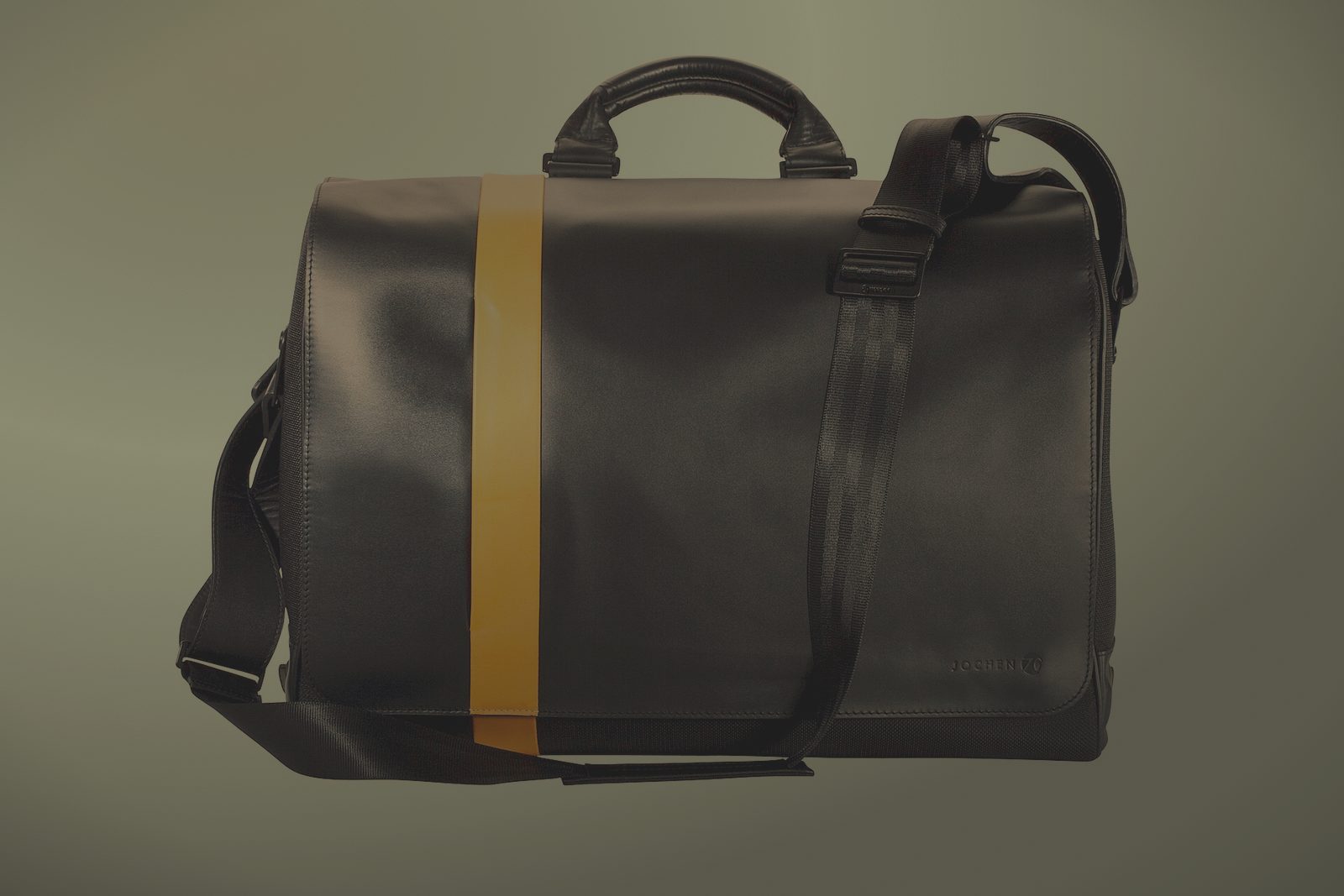 Before relighting: leather messenger bag, kitchen table — dark, shadowy photo