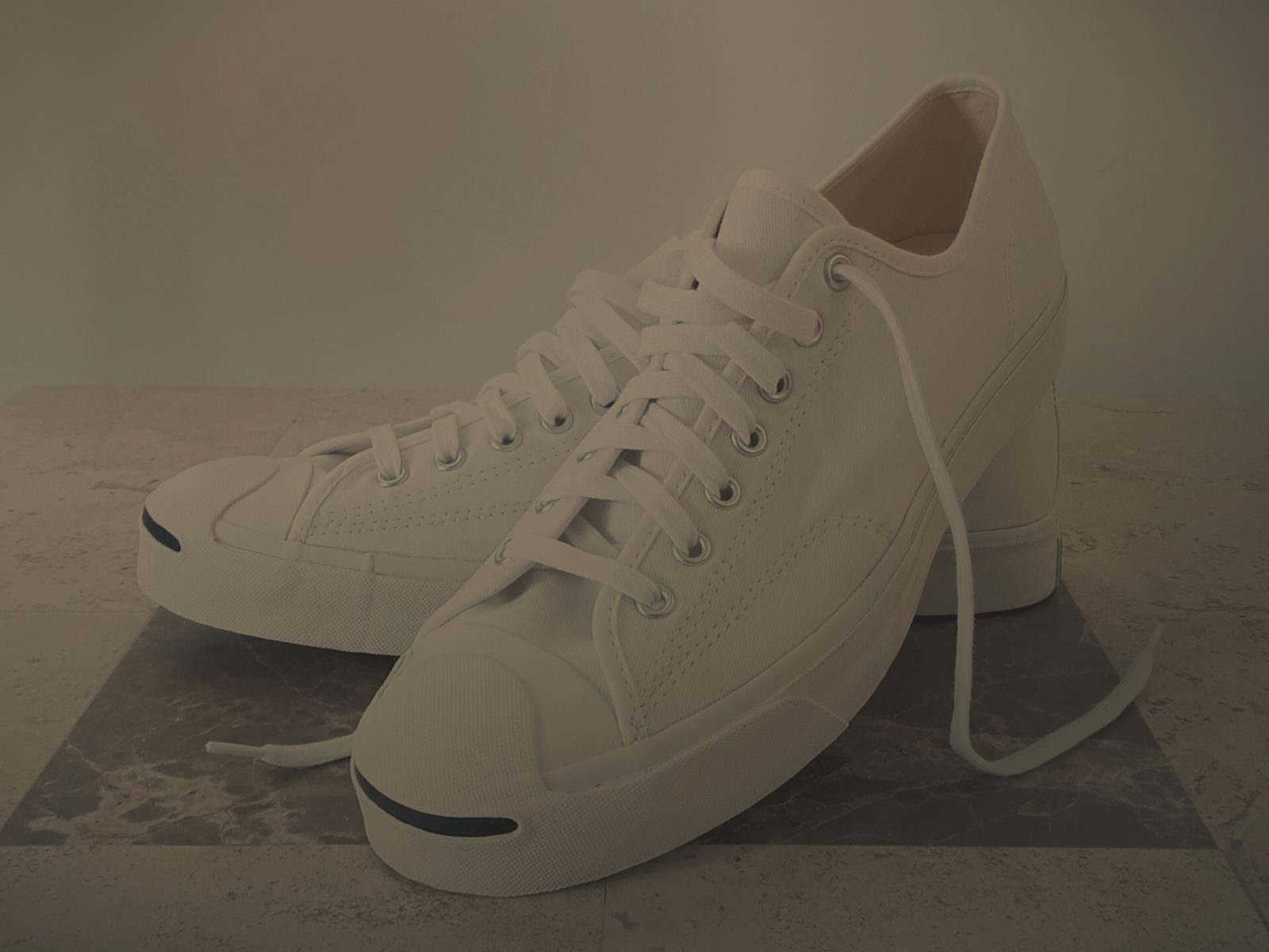 Before relighting: white canvas sneakers, dim room — the photo looks dark and shadowy